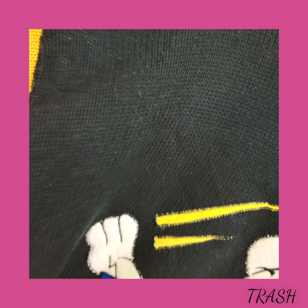 Black fabric with white paw print and yellow accents on a pink background, labeled 'TRASH'.