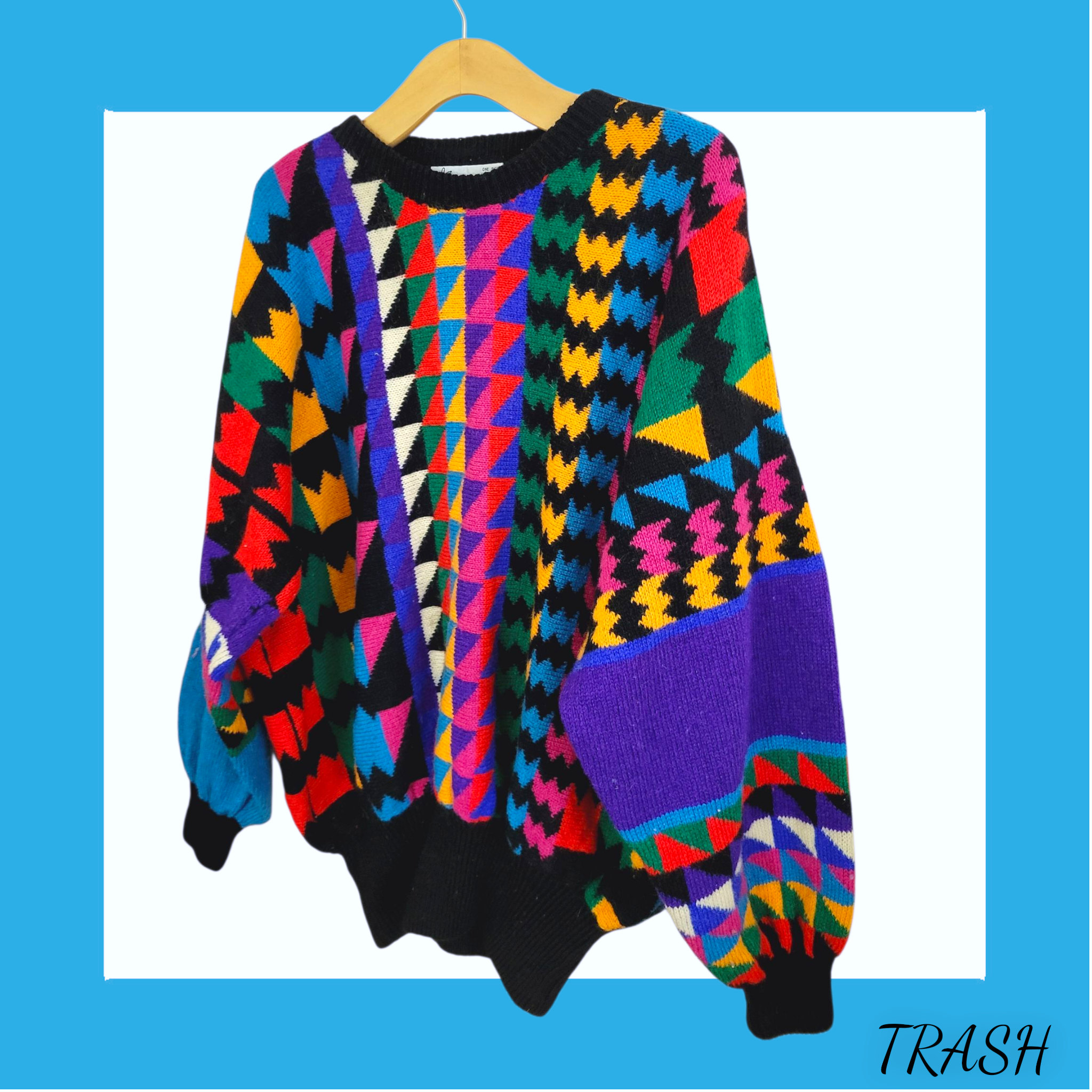 Colorful geometric-patterned sweater on a hanger against a blue background with 'TRASH' text.