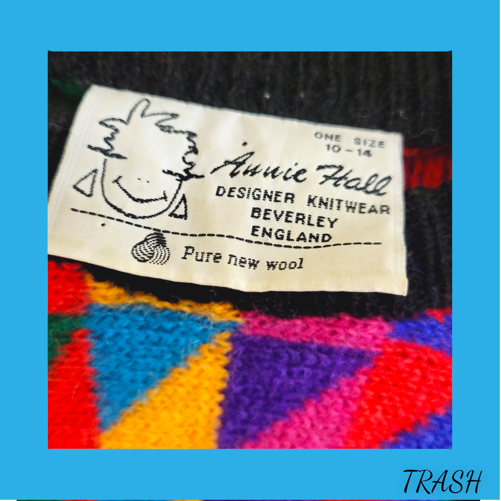 Colorful knitted fabric jumper with a 'Annie Hall' label on a blue background