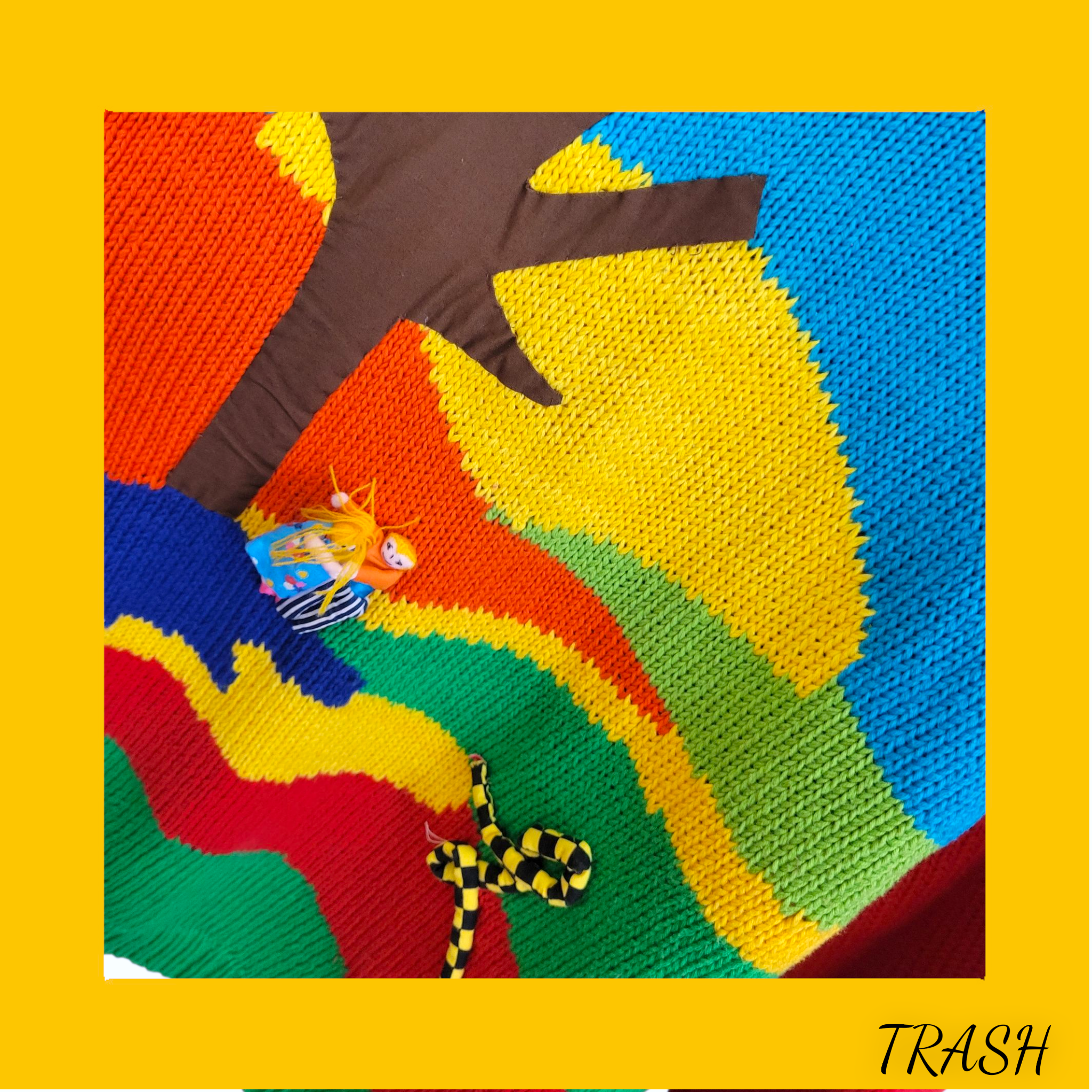 Colorful knitted vintage ugly jumper with cartoon character and 'TRASH' text on a yellow border